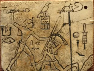 Ancient ivory plaque with incised figures showing a standing ruler raising a mace over a kneeling figure, with symbols and a sandal shape beside them.