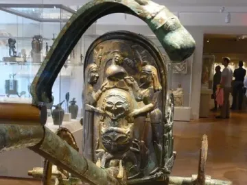 Monteleone Chariot bronze chariot with relief decorations and a stylized face on display in a museum