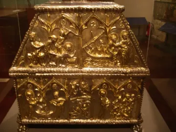Sant Cugat Casket with a sloped lid, covered in intricate embossed scenes and small figures within arched panels.