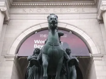 Theodore Roosevelt Equestrian Statue with a rearing horse and two standing figures in front of the American Museum of Natural History.