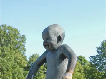 Angry Boy bronze statue of a crying toddler with clenched fists on a pedestal.