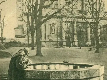 Sepia-toned view of the Saint Francis Fountain with a robed figure leaning over the carved stone basin as water flows into the lower pool.