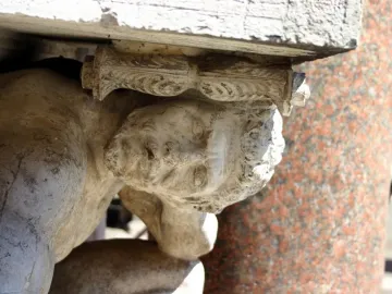 Close-up of Il Gobbo di Rialto, showing a weathered stone crouching figure supporting a carved element.