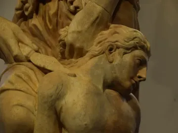 Marble sculpture of The Sacrifice of Isaac showing a raised hand holding a dagger above a bowed, bare-chested figure.