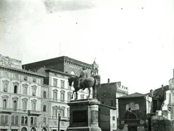 Victor Emmanuel II Monument seen from a city square, with a rider on horseback atop a tall stone pedestal.
