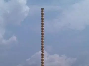Colonne Pascale, a tall segmented column standing outdoors among buildings and vehicles.