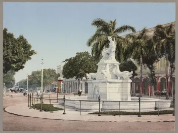 Fuente de la India fountain with a seated female statue and dolphin sculptures in a street median