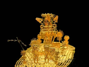 Muisca Raft with stylized gold figures on a raft-shaped base, featuring a larger figure with an elaborate headdress at the back.