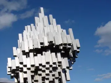 Norra skenet stainless steel sculpture with reflective metal bars rising diagonally on a lawn.