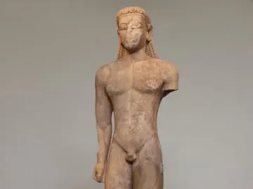 Sounion Kouros marble statue of a nude male youth with long braided hair, shown front-facing with a missing left arm.