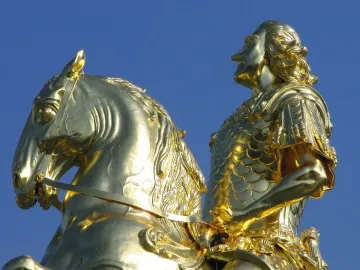 The Golden Rider equestrian statue in Dresden, showing a gilded man on a rearing horse against a blue sky.
