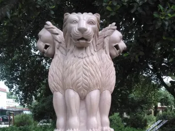 Lion Capital of Ashoka with three lions standing back-to-back above a carved drum and bell-shaped base.