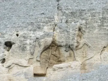 Madara Rider rock relief carved into a grey cliff face, with a vertical crack running through the carving.