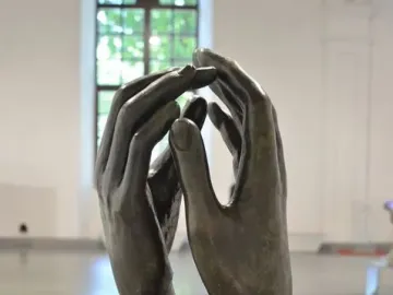 The Cathedral bronze sculpture with two hands reaching upward and nearly touching