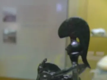 Warrior of Moixent horse-and-rider figurine with a crested helmet and round shield on a museum display stand.