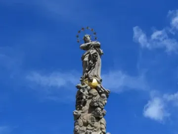 Marian Column in Košice with a tall carved stone column topped by a female statue and halo of stars.
