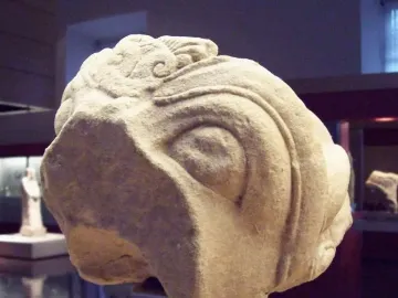 Grifo de Redován stone sculpture with a carved eye and ornate swirling details.