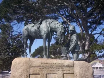 Horse Memorial with a dark metal horse statue and kneeling soldier on a granite base