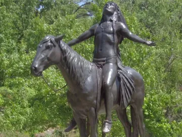 Appeal to the Great Spirit bronze sculpture of a bare-chested man seated on a horse with his arms raised upward.