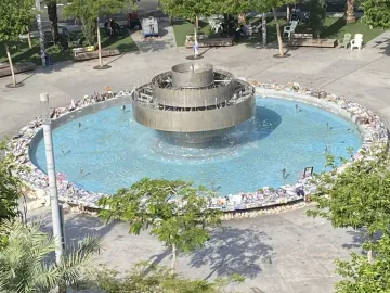 Top-down view of the Fire and Water Fountain with a circular basin, a tiered central structure, and small jets spraying water.