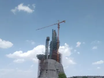 The Statue of Belief under construction, with scaffolding and a crane around its unfinished upper sections.