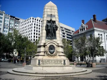 Stephenson Memorial with bronze figures of two men in military uniforms holding a flag above a circular medallion on a tiered stone base.