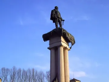 Monument to Vittorio Emanuele II with a bronze statue atop a fluted column and sculpted figures at the base.