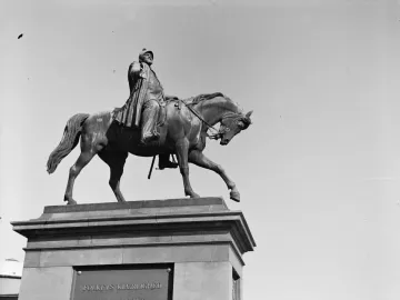 The equestrian statue of Christian V stands on a stone pedestal against a clear sky.