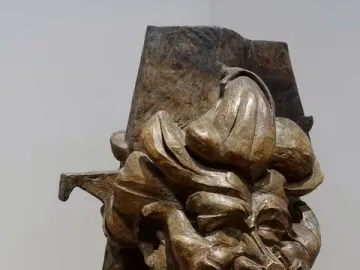 L\'antigrazioso, a bronze-toned abstract bust with angular fragmented forms and a distorted face.