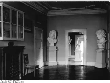 Marble head of Antinous Mondragone on a tall pedestal in a room with other classical sculptures.