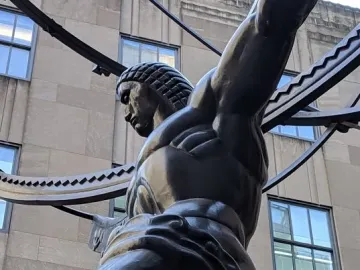 Atlas statue kneeling and holding a large curved structure at Rockefeller Center
