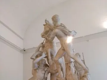 The Farnese Bull marble sculpture showing a dramatic scene with two men struggling to subdue a bull and a female figure beneath it.
