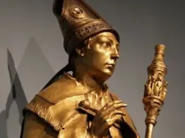 Saint Louis of Toulouse shown as a gilded standing statue holding a staff and a small book.