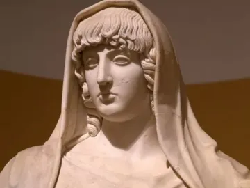 Upper torso of the Giustiniani Hestia marble statue, showing a veiled female figure with wavy hair and draped folds across the chest.