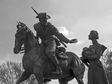 National Women’s Monument statue group showing a man on horseback reaching toward a woman holding a baby.