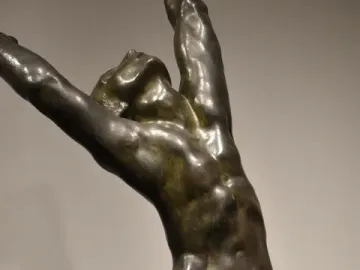 The Prodigal Son bronze sculpture showing a muscular nude male figure with arms raised and head thrown back.