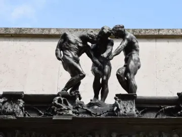 The Three Shades by Rodin, showing three dark bronze nude figures grouped together with bowed heads.