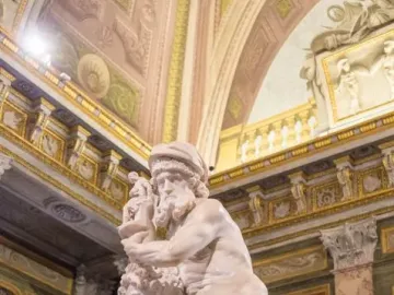 A marble sculpture of Aeneas, Anchises and Ascanius showing a man carrying an older man while a child clings to his leg.