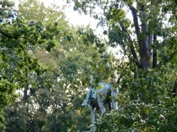 The Major General John A. Logan bronze equestrian statue on a tall pedestal in a park, with trees and buildings in the background.