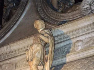 Saint Proculus marble statue in flowing robes against an ornate carved marble backdrop.