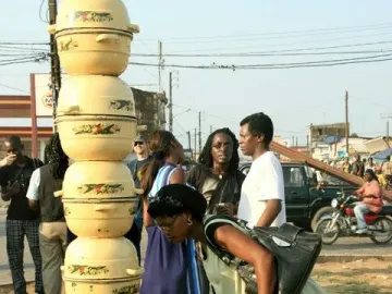 Colonne Pascale, a tall pale yellow column made of stacked pots with decorative bands, standing on a reddish base outdoors.