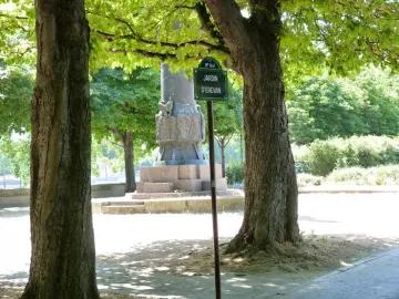 Lower section of the Monument to Mickiewicz, showing a sculpted stone base between trees near the Jardin d\'Erevan sign.