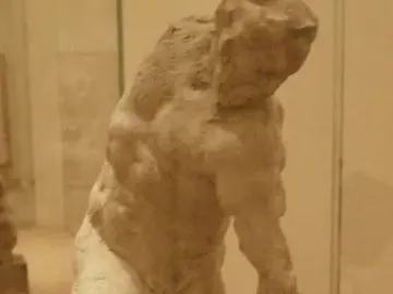 Michelangelo\'s Two Wrestlers, an earthen-toned sculpture of two muscular male figures locked in a wrestling struggle.