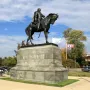 Custer equestrian statue on a stone pedestal with CUSTER carved on the front