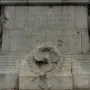 Titanic Engine Room Heroes Memorial stone inscription with carved figures, a ship\'s propeller, wreath, and anchor relief.