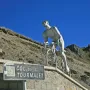 Géant du Tourmalet sculpture of a cyclist climbing against rugged mountain peaks.