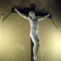 Benvenuto Cellini crucifix showing a white marble Christ figure on a dark wooden cross with INRI at the top.