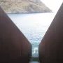Steep rust-colored metal staircase descending between tall walls at the Walter Benjamin Memorial in Portbou.