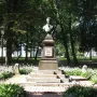 Bronze bust of Pushkin on a dark pedestal in a misty park.