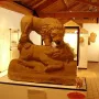 Corbridge Lion sculpture displayed on a white pedestal in a museum gallery